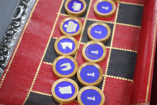 A 19th century Jaques Patent portable B.C.D. backgammon, chess and draughts board set, the gilt tooled red morocco cylinder holder